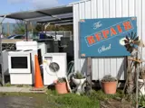 Products sitting outside a building that require repairing at The Repair Shed.